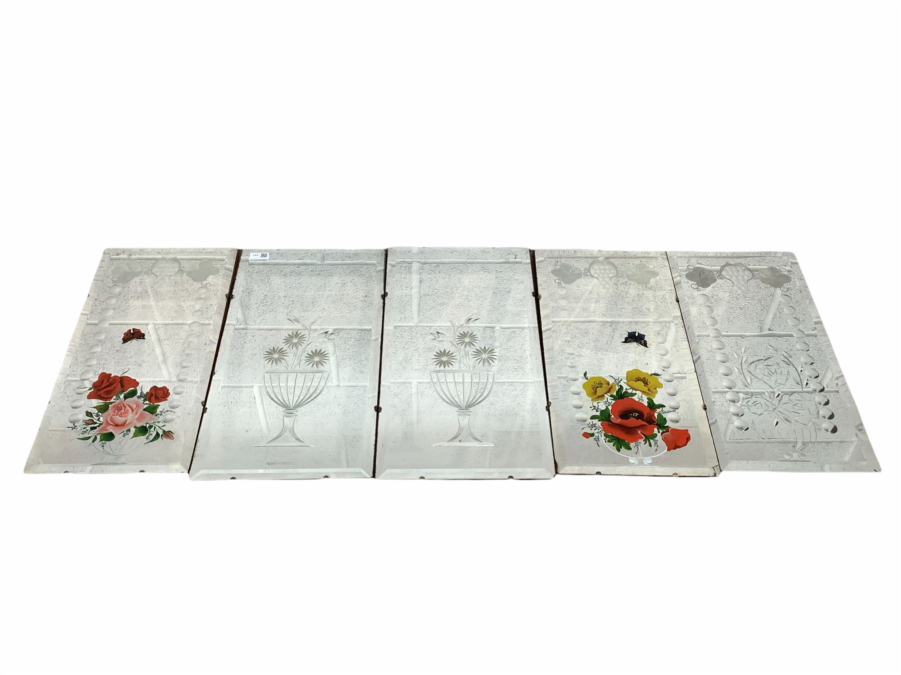 Pair of bevelled mirror panels engraved with floral bouquets issuing from fluted vase