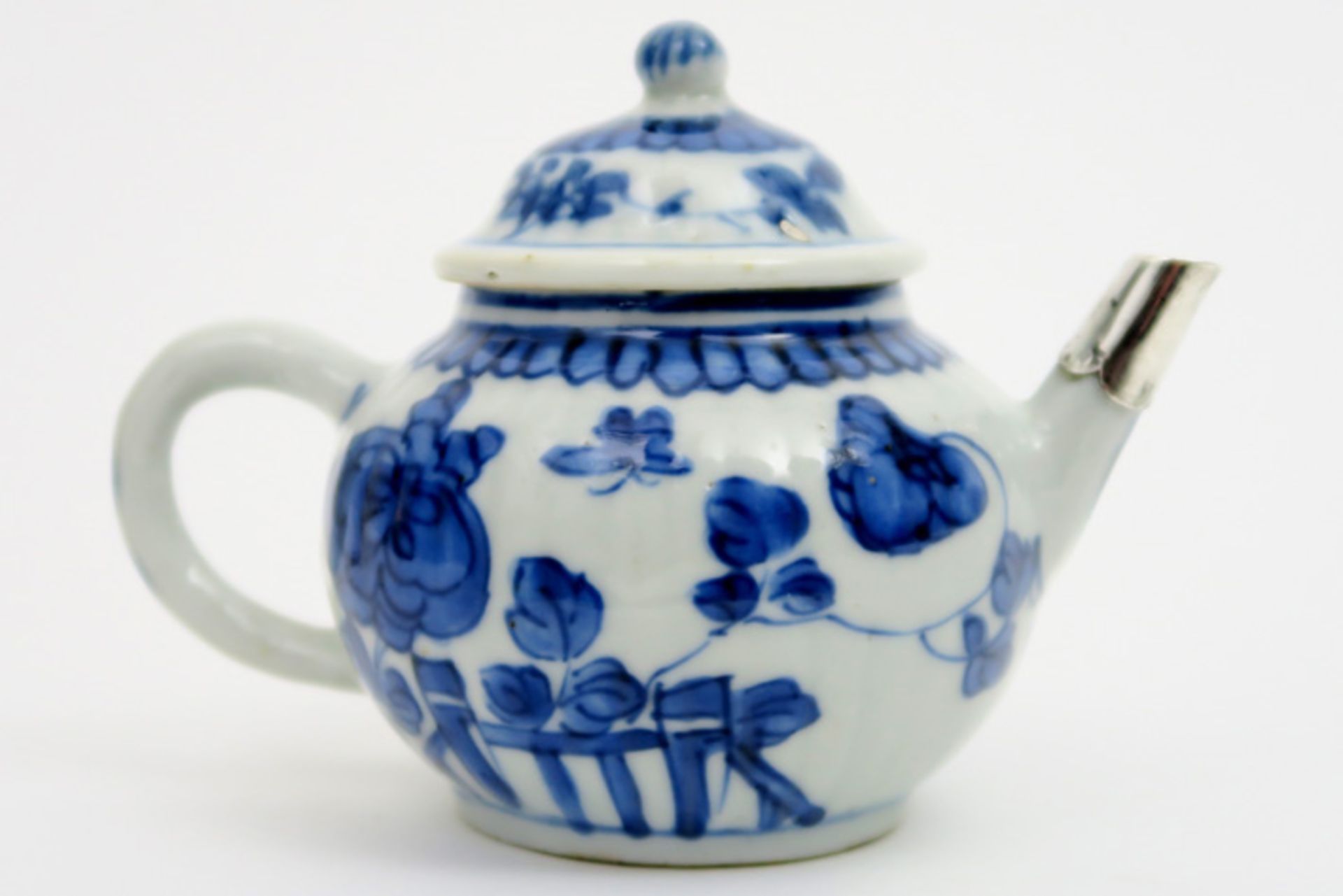 18th Cent. Kang Xi tea pot in porcelain with blue-white flower and butterfly decor and with silver
