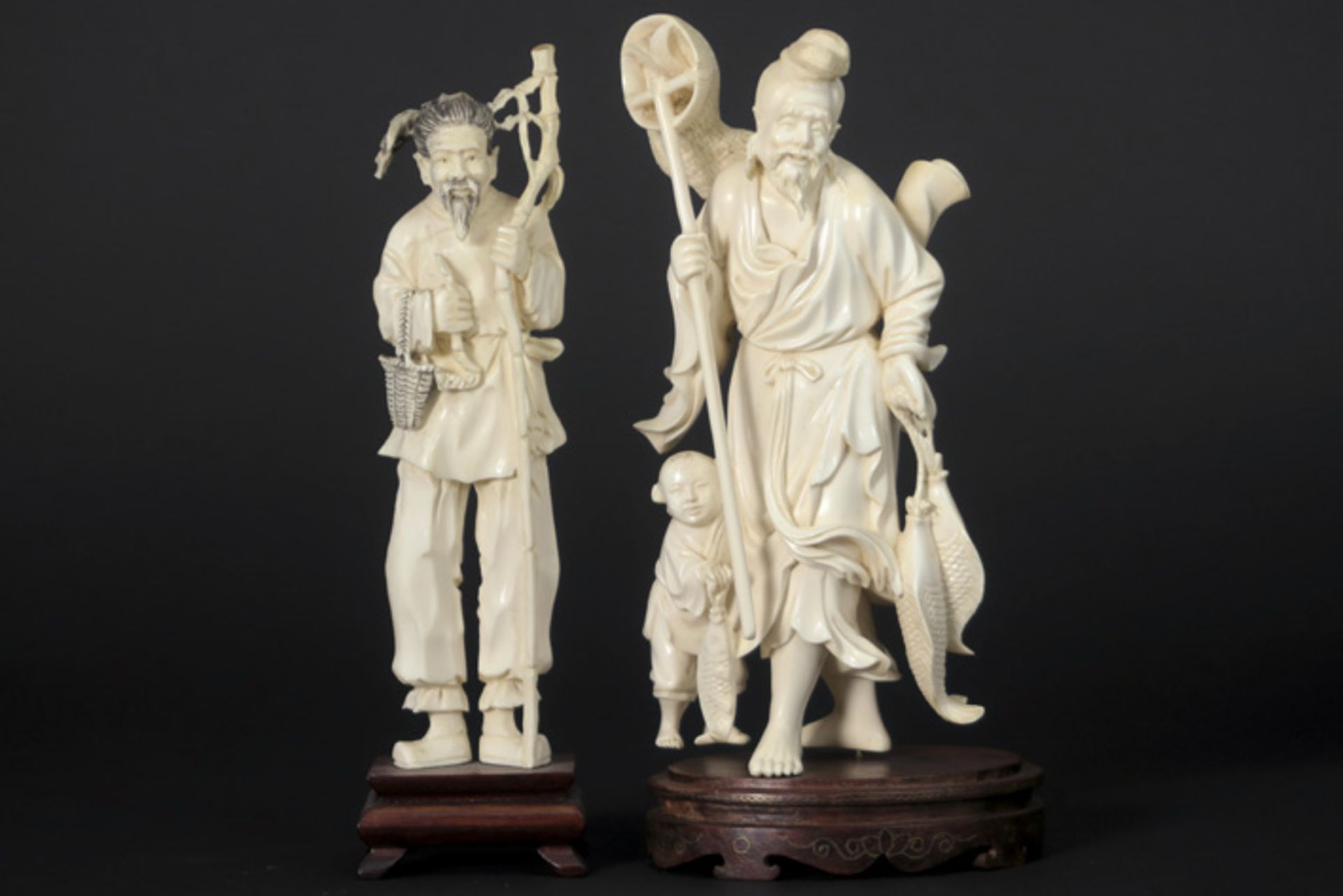 Lot van twee Chinese sculpturen in ivoor : "Man met staf" en "Visser met kind" - hoogtes : 18 en