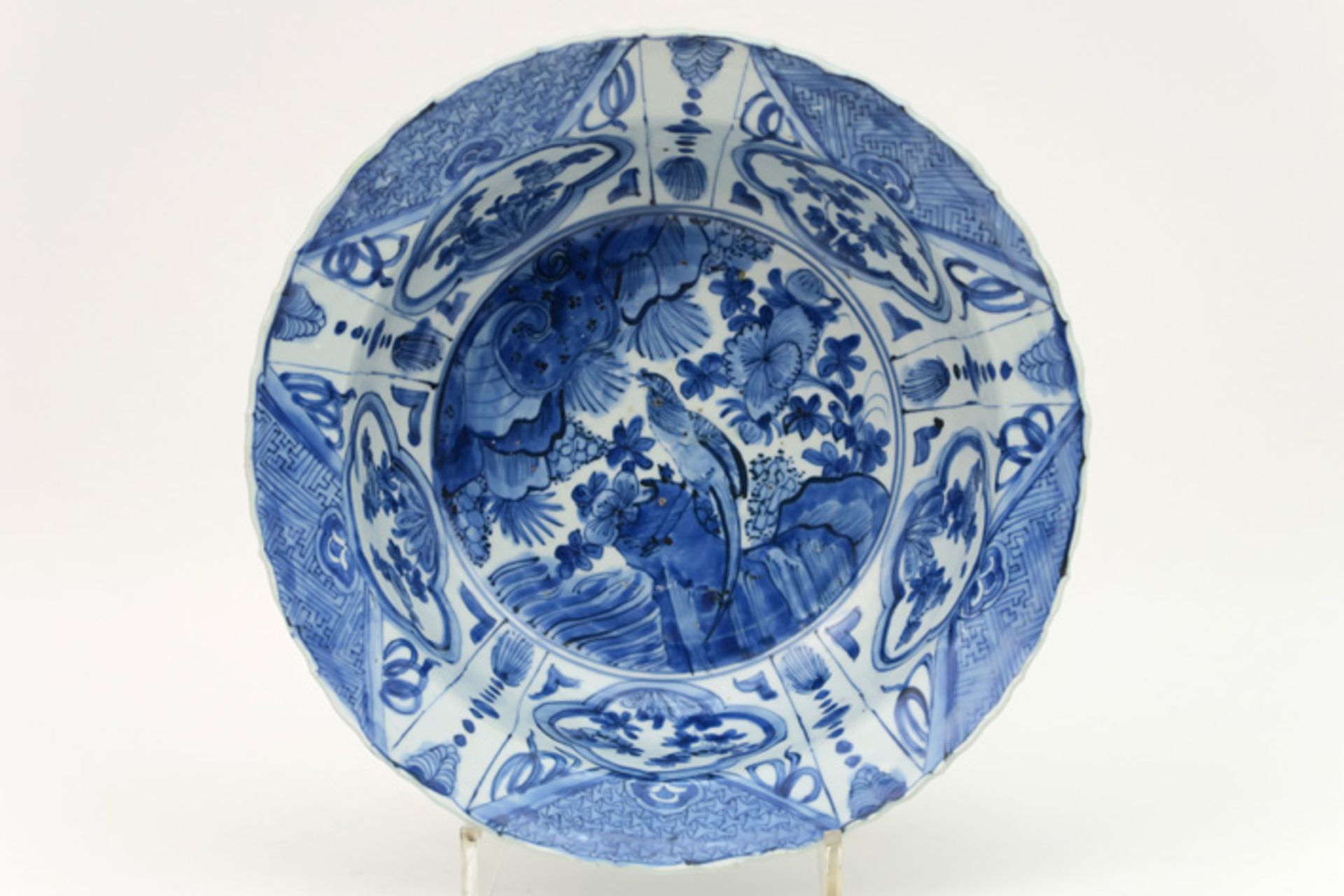 Chinese bowl met gekartelde rand in porselein met een blauwwit decor met centraal een tuinzicht