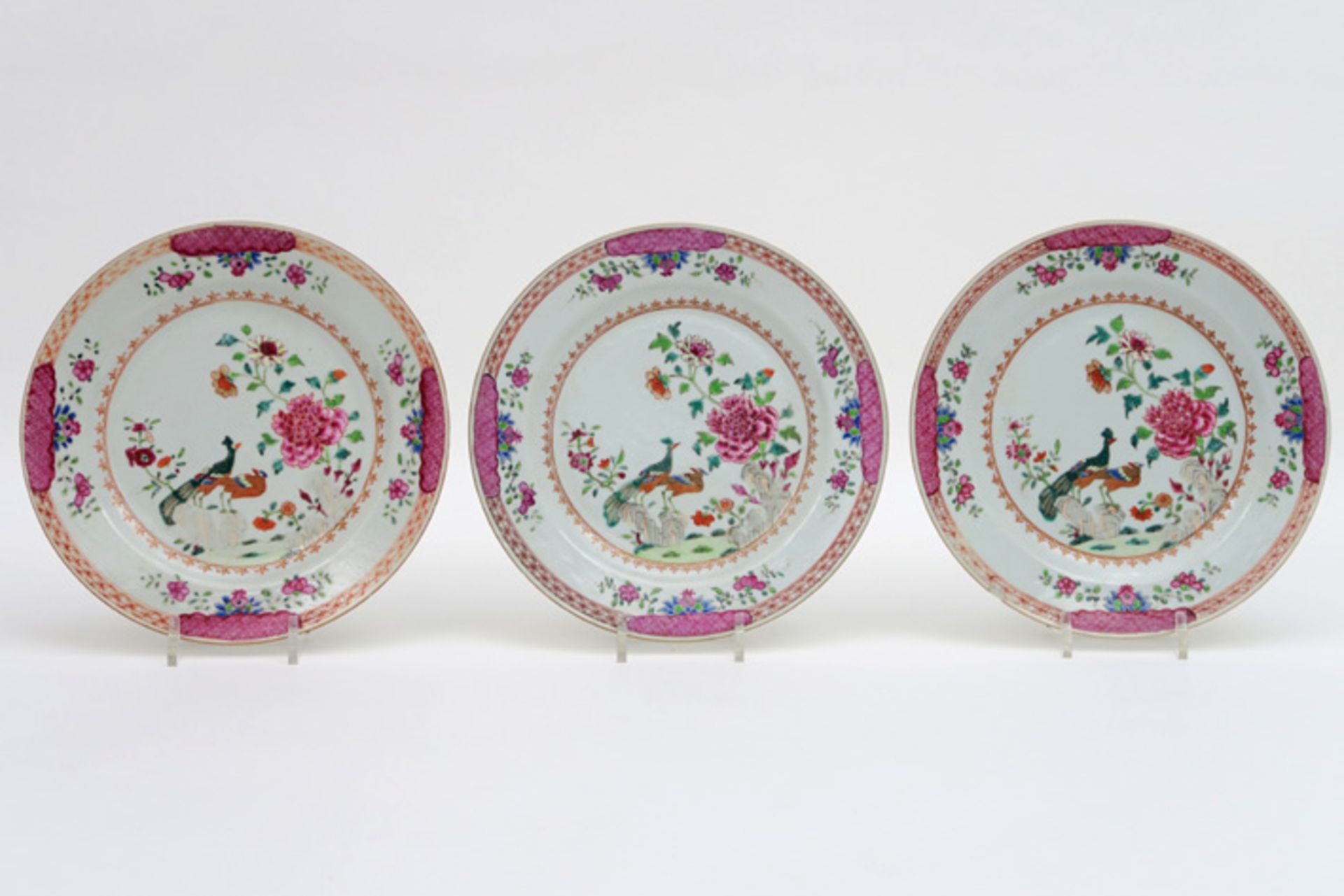 Set van drie achttiende eeuwse Chinese borden in porselein met Famille Rose-tuindecor met pauwen -