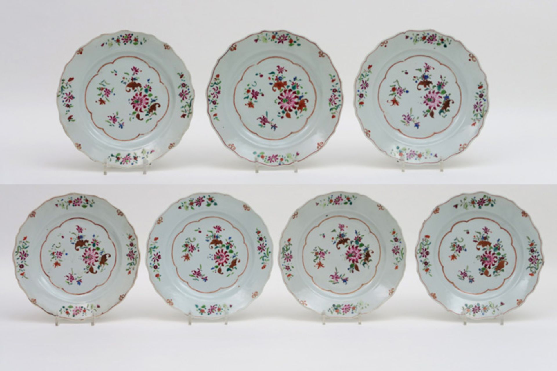 Reeks van zeven achttiende eeuwse Chinese borden met gegolfde rand in porselein met Famille Rose-