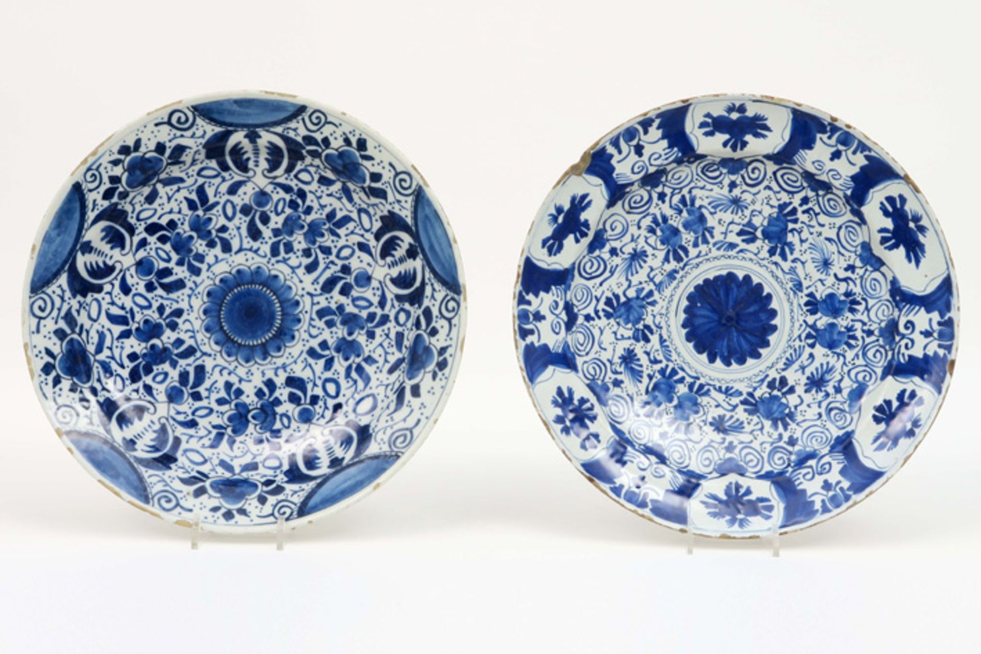 pair of quite large round 18th Cent. dishes in ceramic from Delft with a blue-white flower decor||Pa