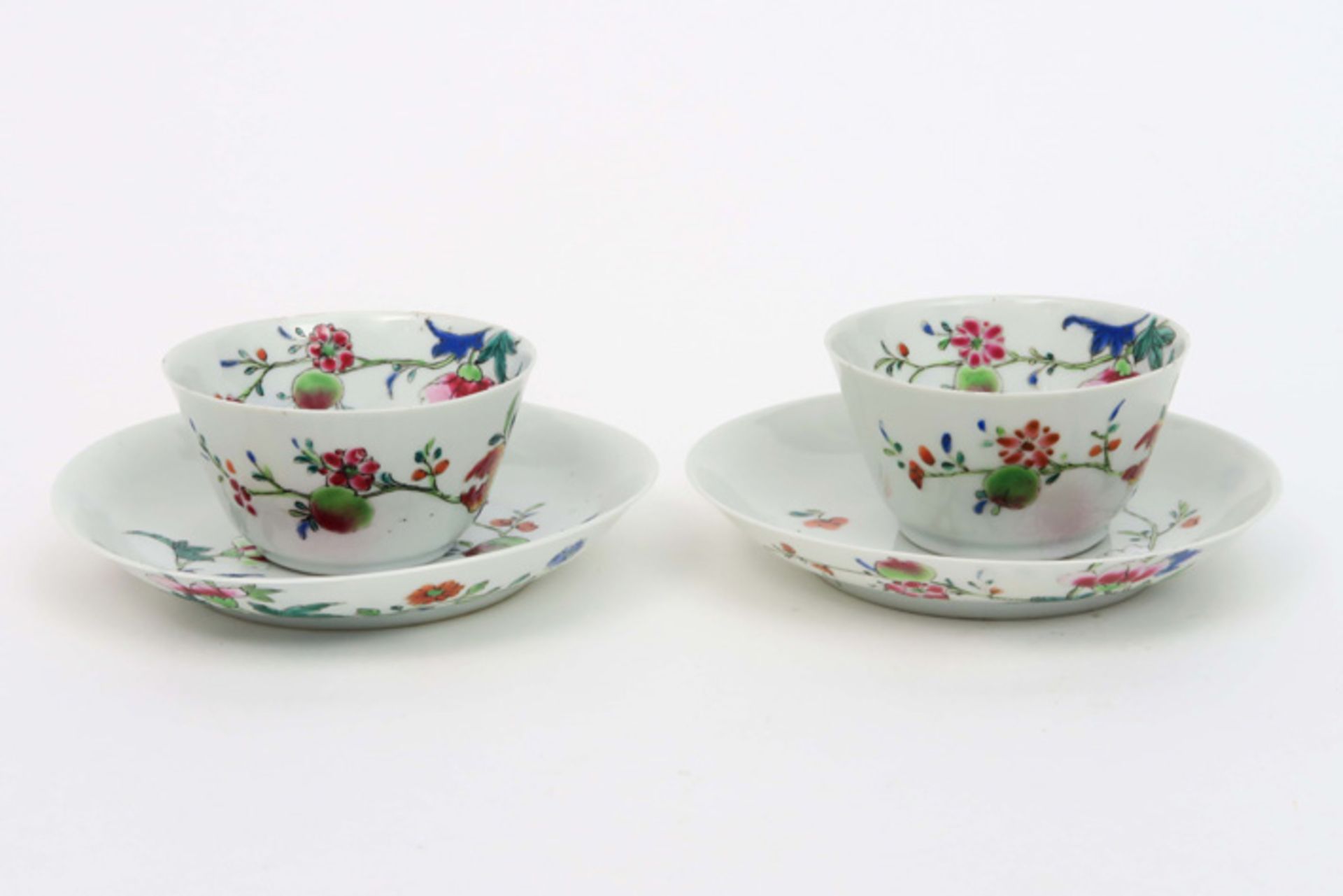 pair of 18th Cent. Chinese sets of cup and saucer in porcelain with a 'Famille Rose' flowers decor||