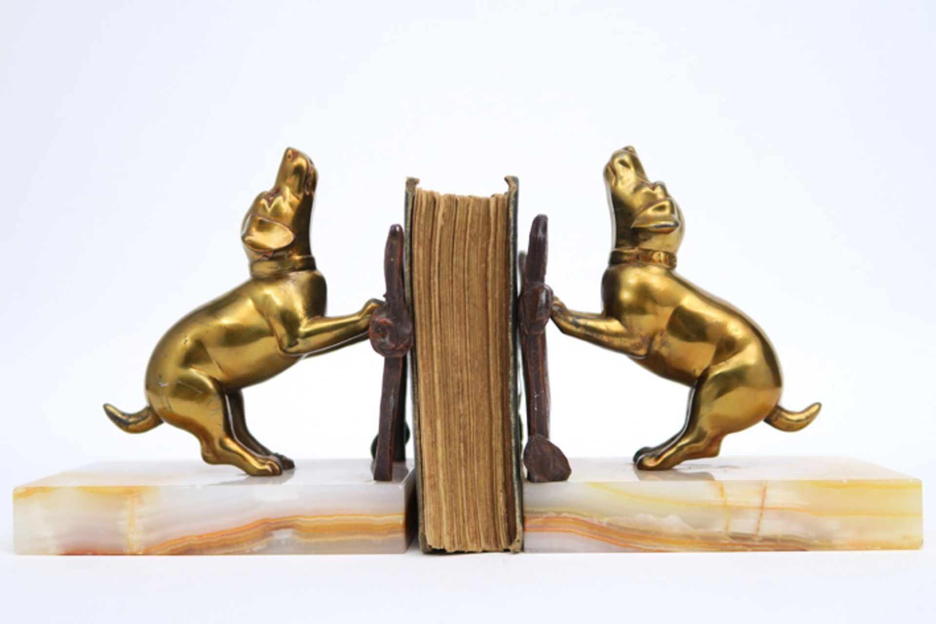 pair of French Art Deco bookstands each with a gilded dog sculpture on its onyx base || Paar Frans