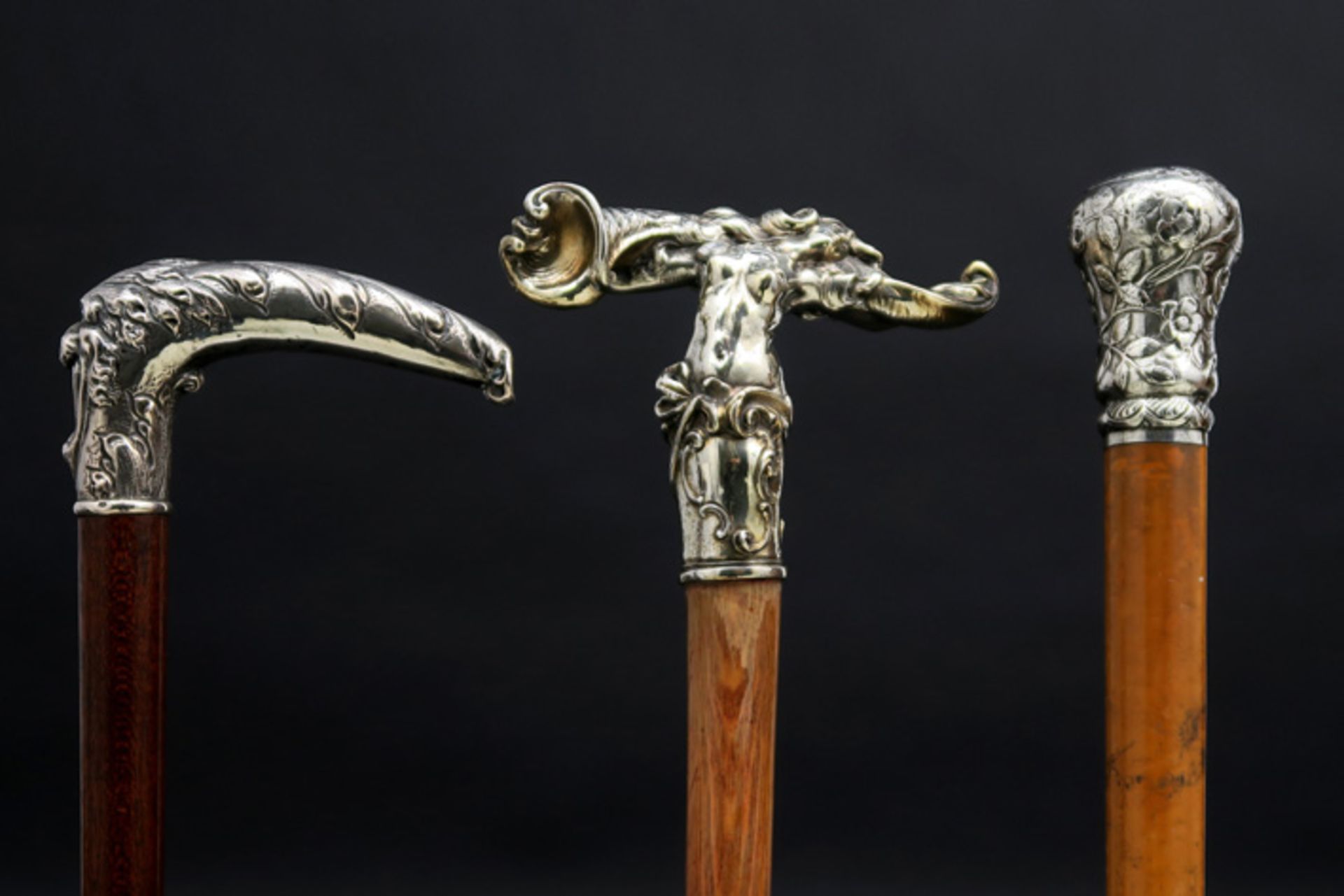 three Art Nouveau walking sticks each with a silverplated grip || Lot van drie Art Nouveau-