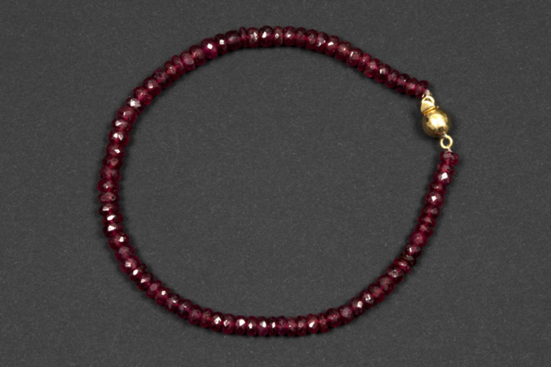 bracelet with ca 20 carat of ruby and a lock in yellow gold (18 carat) || Fijn bracelet met één rang