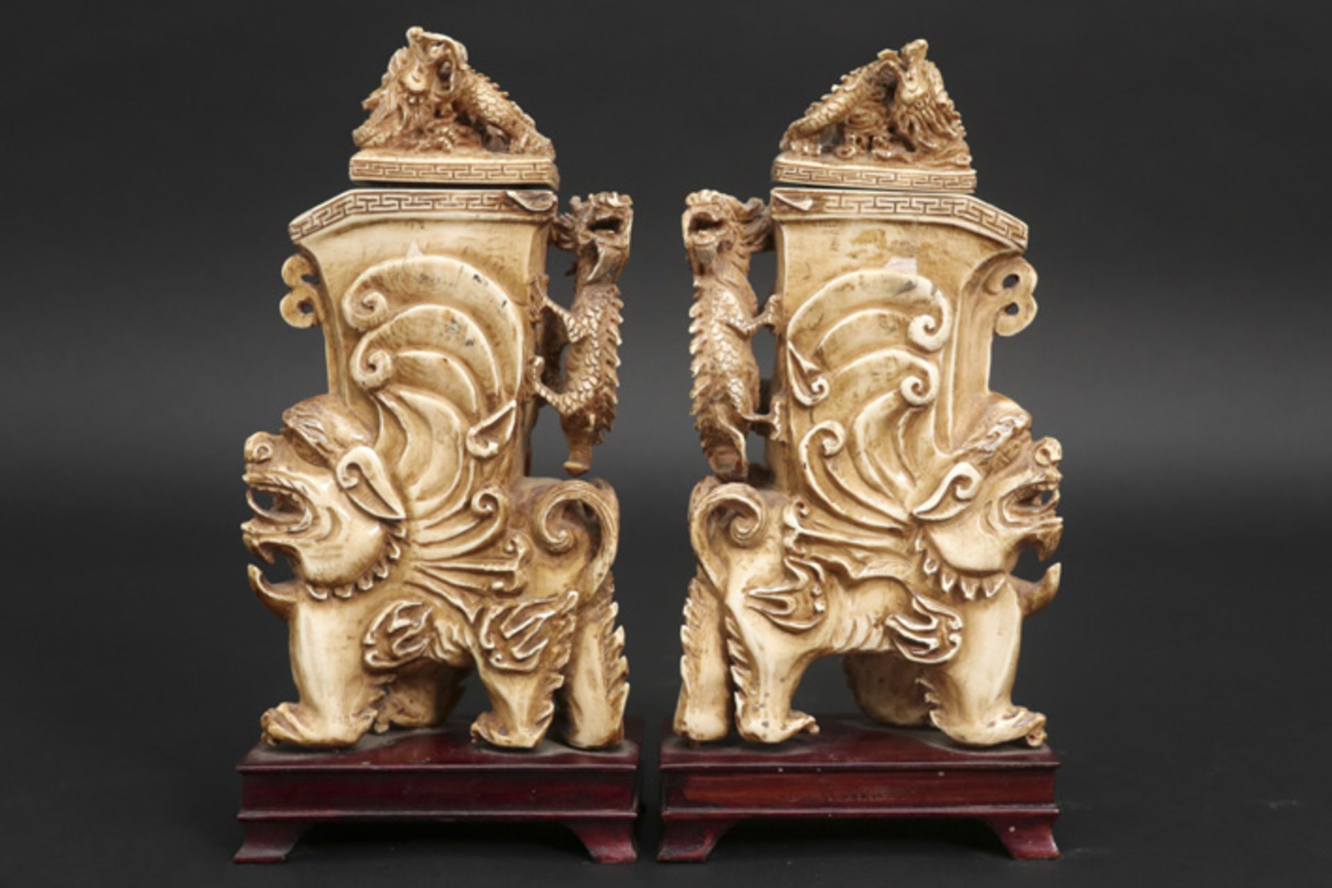 pair of Chinese ornamental sculptures, each with a lidded vase, in ivory || Paar Chinese