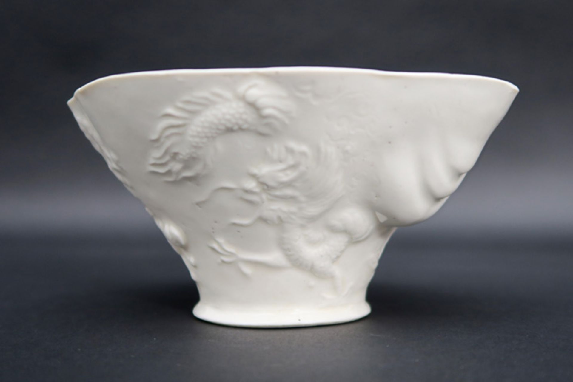 Chinese cup in "blanc de Chine" porcelain with a relief decor with mythical animals (deer,
