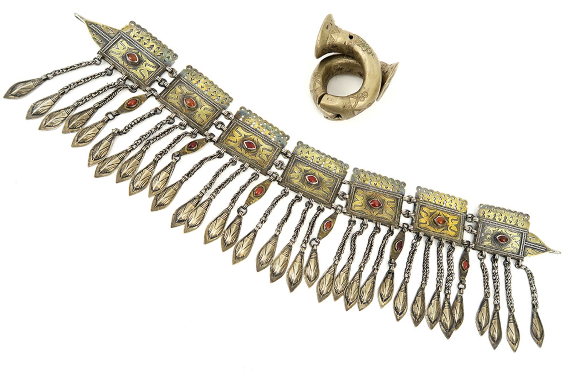 old African silver bracelet and an antique Turkmen jewel in silver, gold and carnelian || Lot (2)