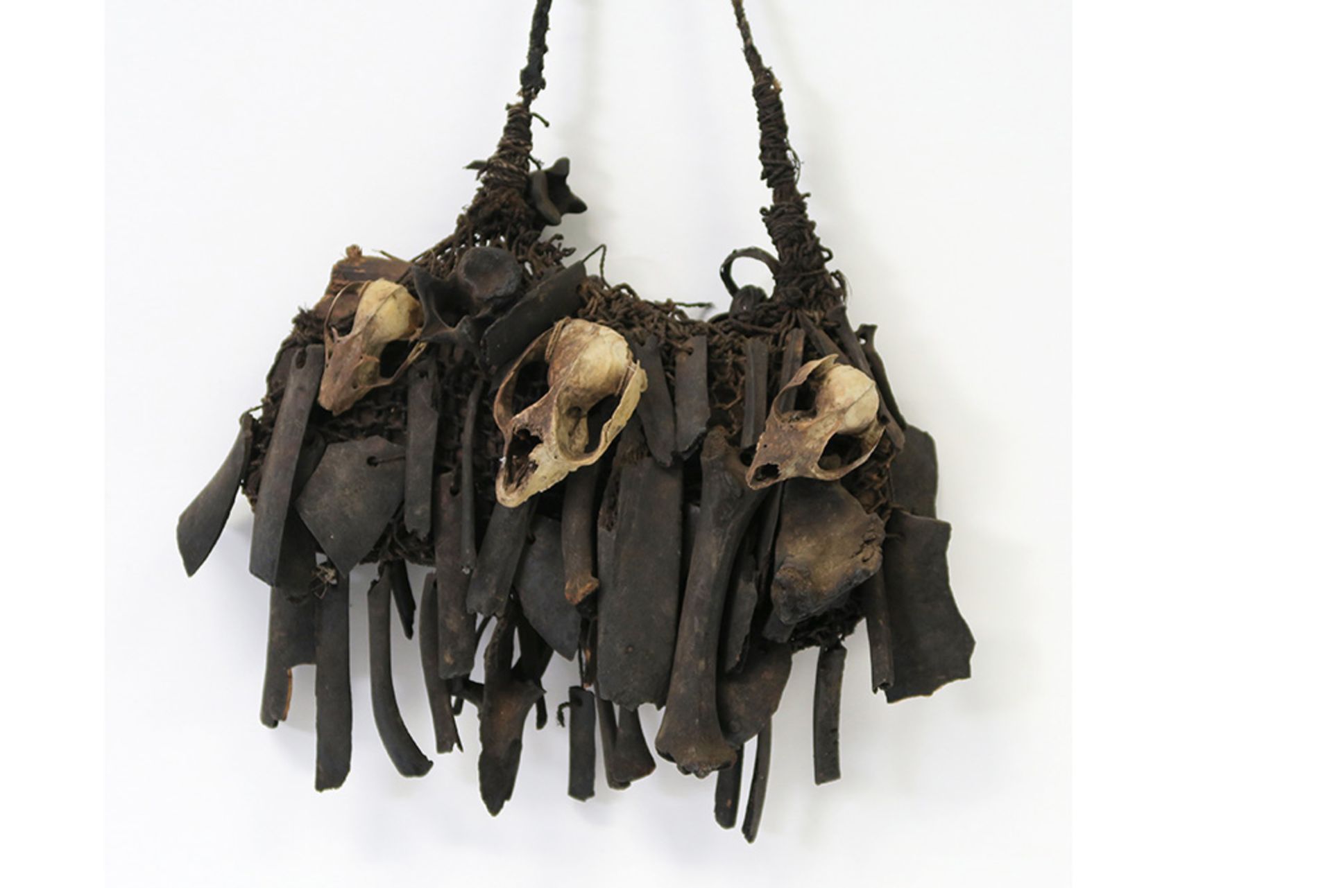 early 20th Cent. Papua New Guinean Asmat magic hunting bag with bones and Marsipulami skulls || - Image 2 of 3