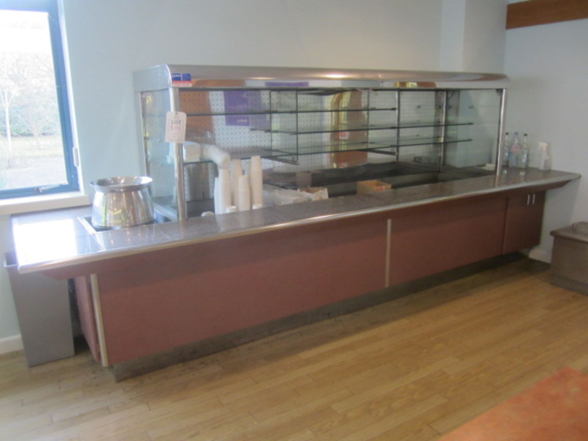 Tiled top serving counter with glass shelf chiller display, under canopy lighting, soup warmer,