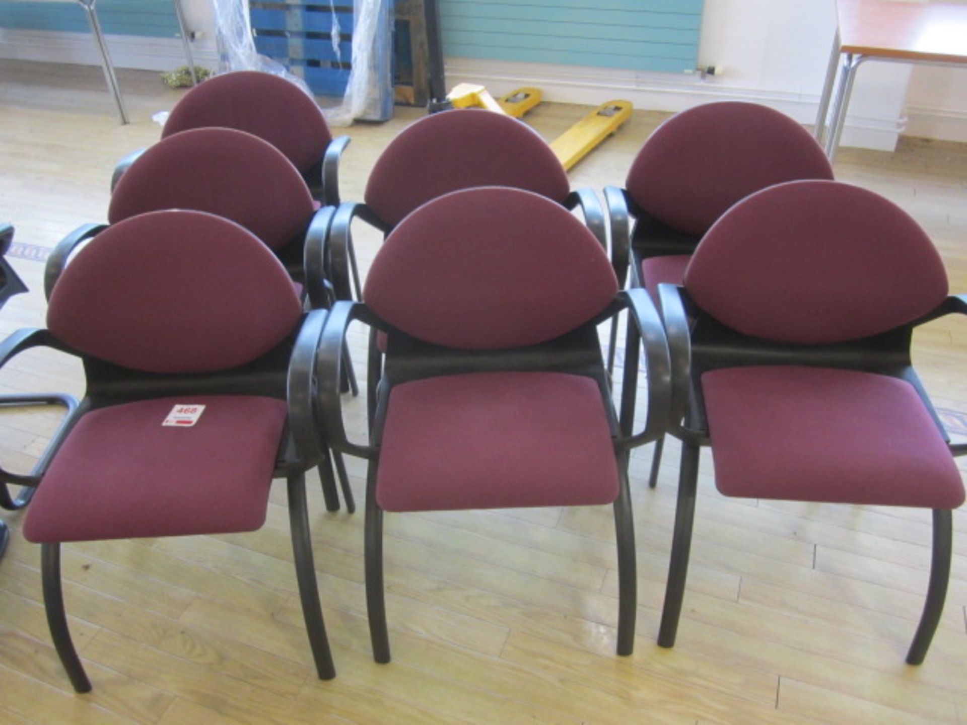 Seven black frame upholstered meeting armed chairs