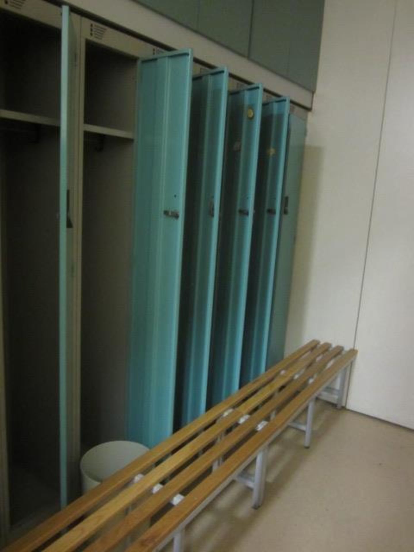Eight metal single door personnel lockers and slatted bench