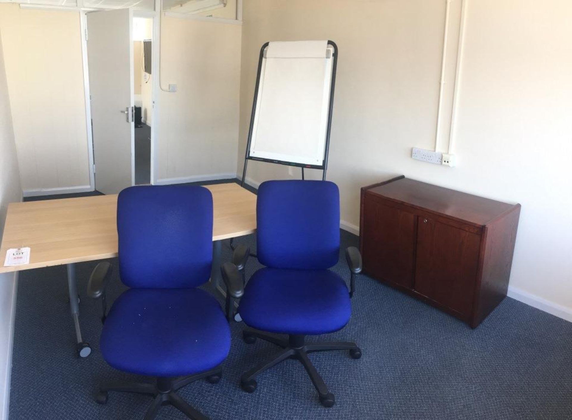 Two swivel chairs, a 2-door cabinet, a flip chart and a light wood veneer table