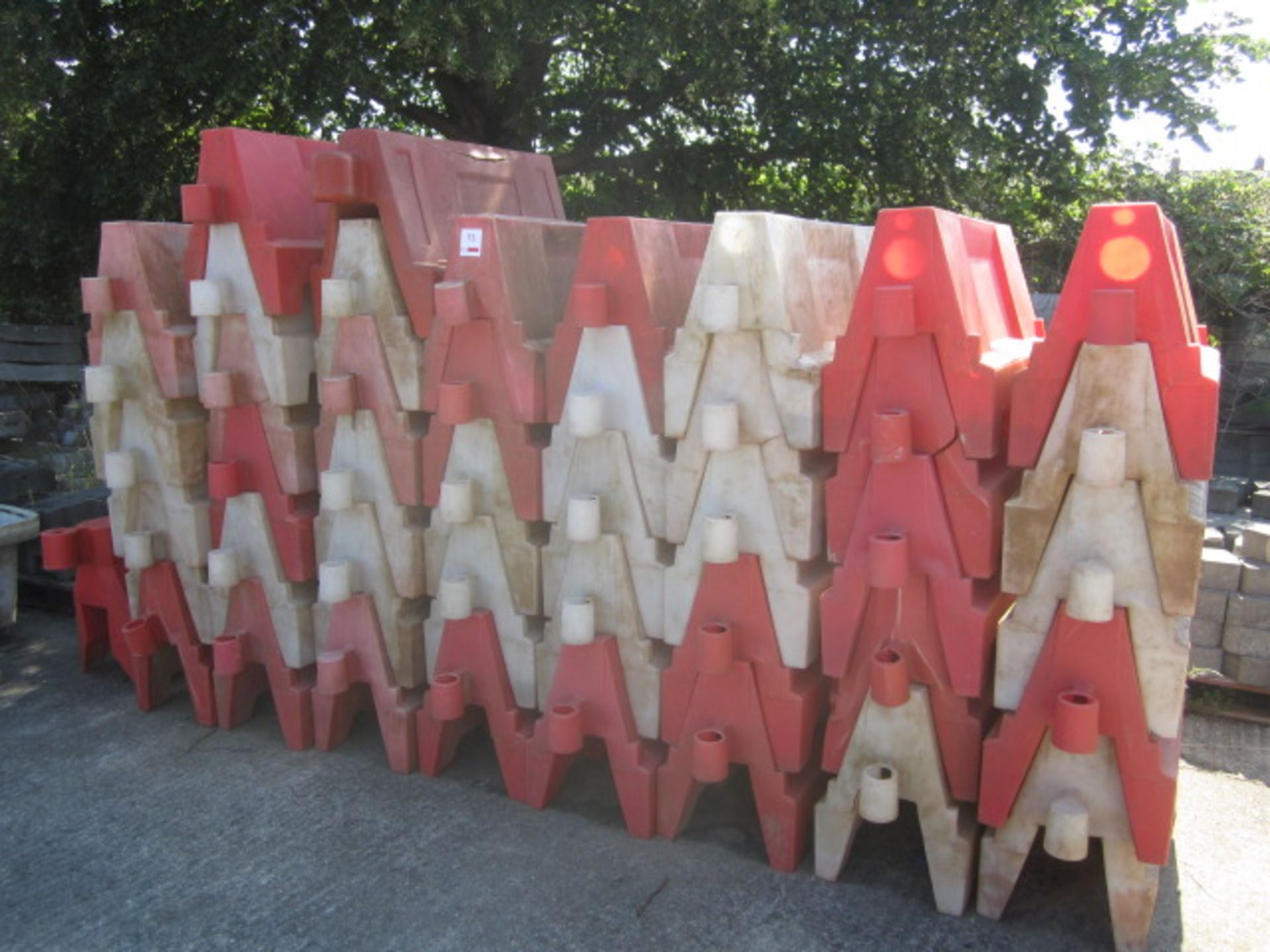 Forty three plastic orange & white barrier blocks, approx. 1000mm width