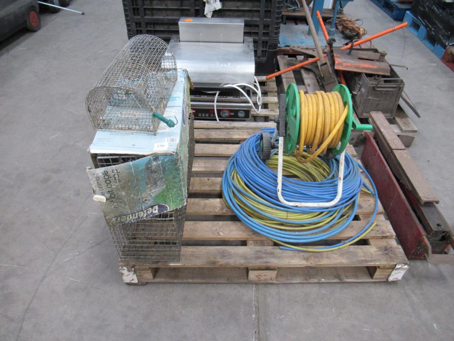 Pallet of animal traps/cages and hose pipes.