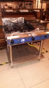 Stainless steel unbadged 4-burner gas Range with griddle on stand (disconnected)