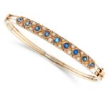 AN ANTIQUE SAPPHIRE AND DIAMOND BANGLE in yellow gold, set with nine graduated cushion cut blue