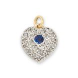 A SAPPHIRE AND DIAMOND HEART PENDANT / CHARM in yellow gold and silver, set with a central round cut