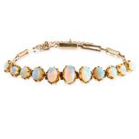 AN ANTIQUE OPAL BRACELET, CIRCA 1900 in yellow gold, set with a row of eleven graduated oval
