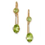 A PAIR OF PERIDOT EARRINGS in yellow gold, each set with an oval cut peridot suspended below a round