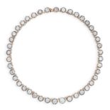 A DIAMOND RIVIERE NECKLACE in high carat yellow gold and silver, comprising a single row of forty-