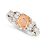 AN IMPERIAL TOPAZ AND DIAMOND RING in platinum, set with a mixed cut topaz between scrolling