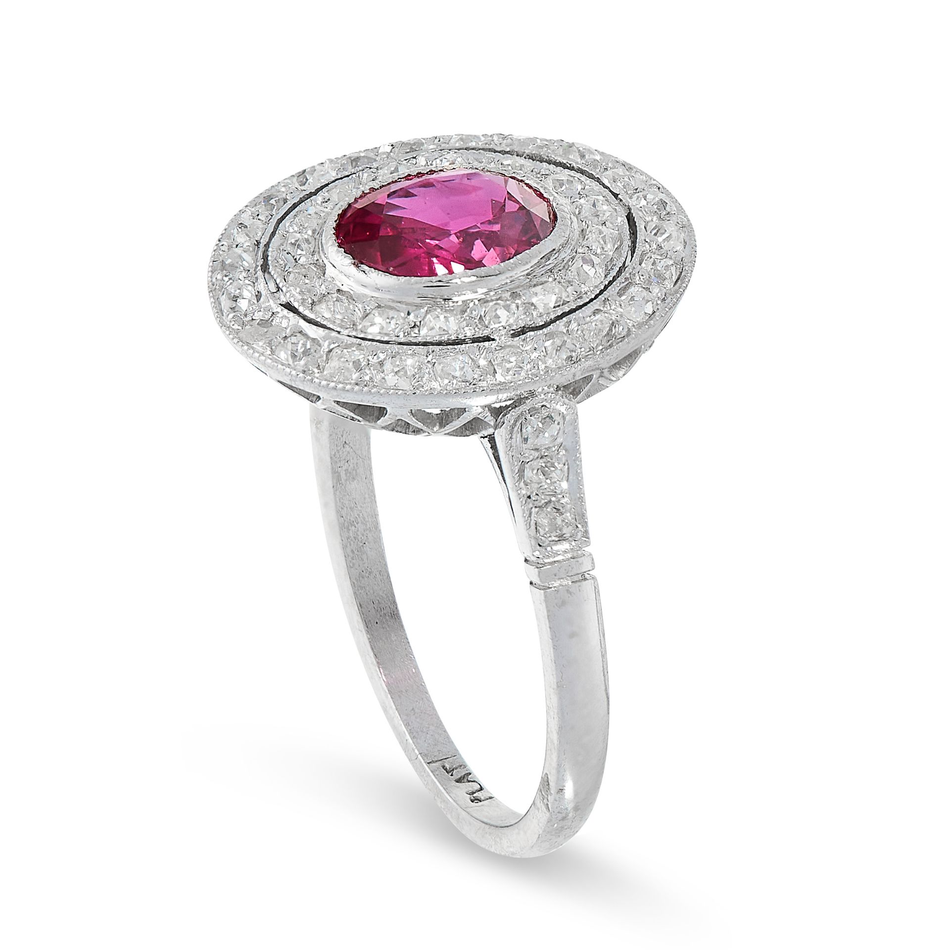 RUBY AND DIAMOND DRESS RING in platinum, set with an oval cut ruby of 1.23 carats within a border