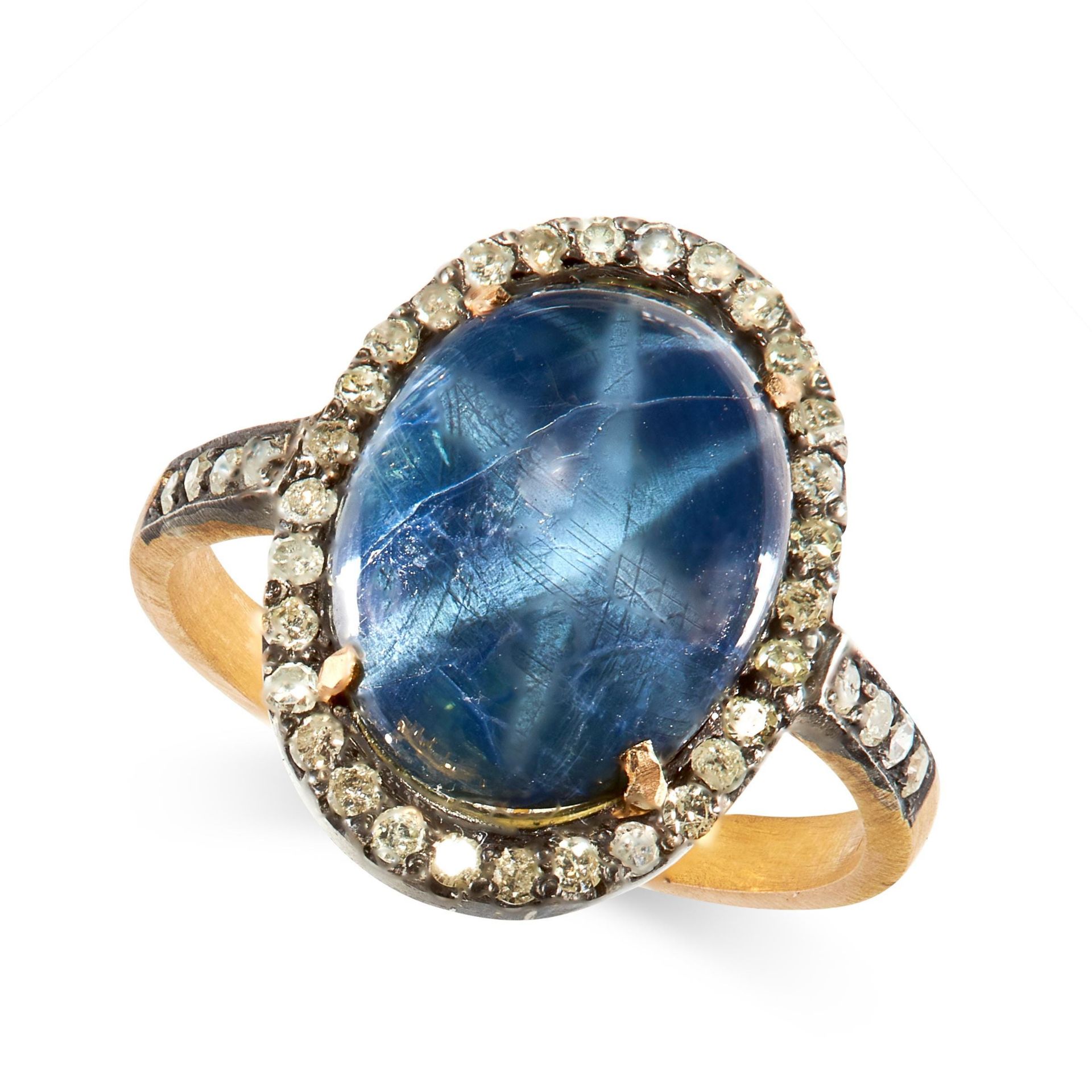 STAR SAPPHIRE AND DIAMOND RING in silver and gold, claw-set with a cabochon star sapphire weighing
