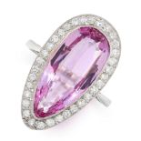 A PINK TOPAZ AND DIAMOND RING in platinum, set with a pear cut pink topaz of 7.11 carats, within a