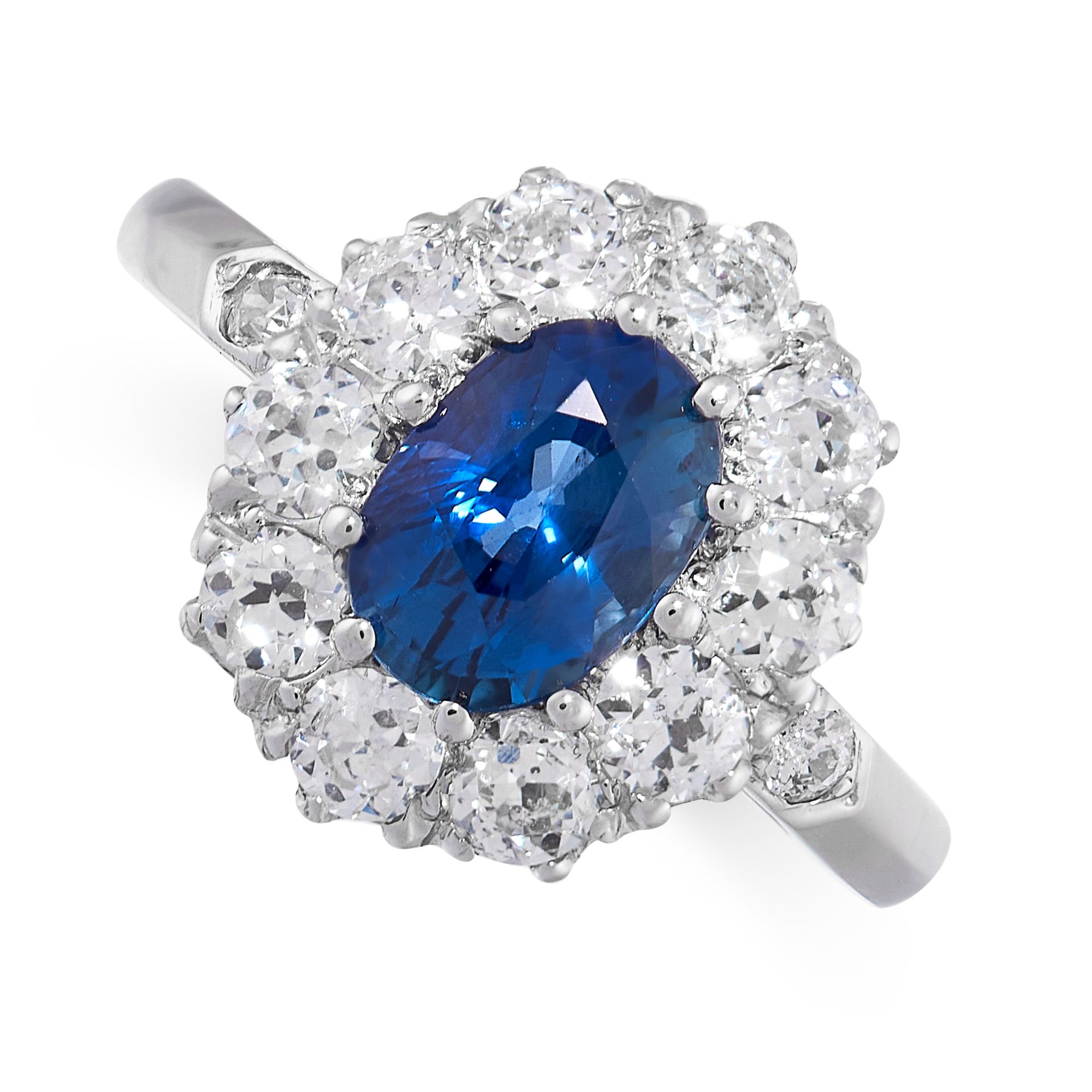 A SAPPHIRE AND DIAMOND CLUSTER RING in platinum, set with a cushion cut blue sapphire of 1.50