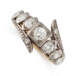 A DIAMOND DRESS RING in yellow gold and silver, the band set with a row of seven round cut and old