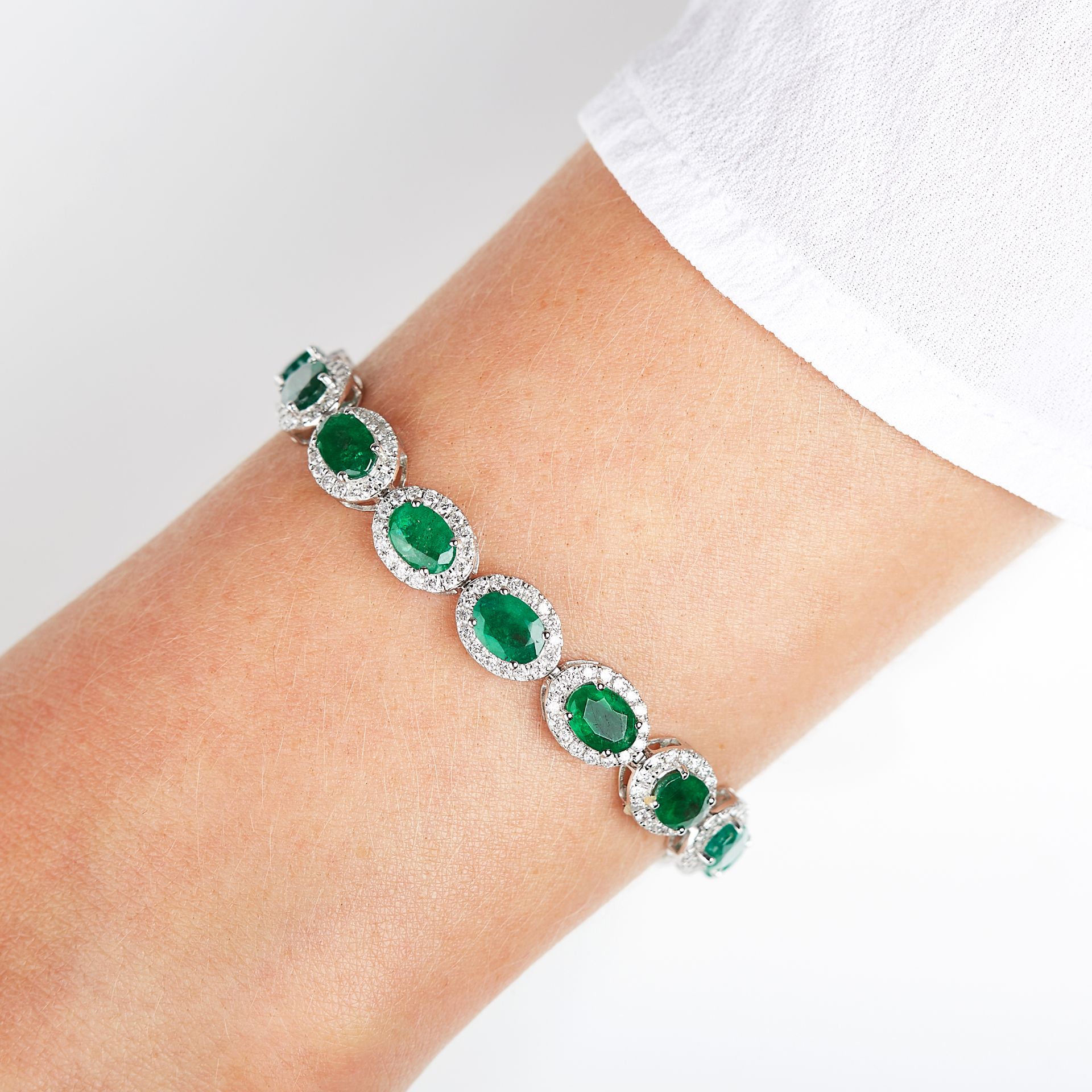 AN EMERALD AND DIAMOND BRACELET in 18ct white gold, set with a series of eighteen oval cut emeralds, - Image 2 of 2