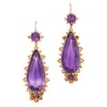 A PAIR OF ANTIQUE AMETHYST EARRINGS in yellow gold, each set with a pear cut amethyst within a