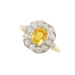 A YELLOW SAPPHIRE AND DIAMOND RING in Art Deco design, set with a cushion cut yellow sapphire of 1.