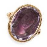 AN AMETHYST CAMEO RING in yellow gold, set with an oval amethyst carved in detail to depict the bust