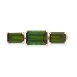 A GREEN TOURMALINE BROOCH in yellow gold, set with three emerald cut green tourmalines, of 13.88,