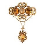 AN ANTIQUE CITRINE BROOCH, 19TH CENTURY in yellow gold, the scrolling body set with a trio of oval