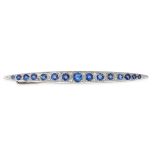 A SAPPHIRE AND DIAMOND BAR BROOCH in platinum, the tapering body set with a row of fifteen graduated