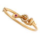 AN ANTIQUE RUBY AND PEARL SNAKE BANGLE, 19TH CENTURY in yellow gold, the hinged body designed as a