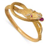 A BURMESE RUBY AND DIAMOND SNAKE BANGLE in high carat yellow gold, designed as the body of a