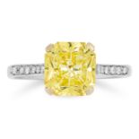 A FINE FANCY VIVID YELLOW DIAMOND AND DIAMOND RING in 18ct white gold, claw-set with a cut-