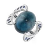 A SAPPHIRE RING set with an oval cabochon blue sapphire weighing 13.57 carats, the shoulders set