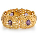 AN AMETHYST BRACELET composed of open work panels of floral design with engraved details, each