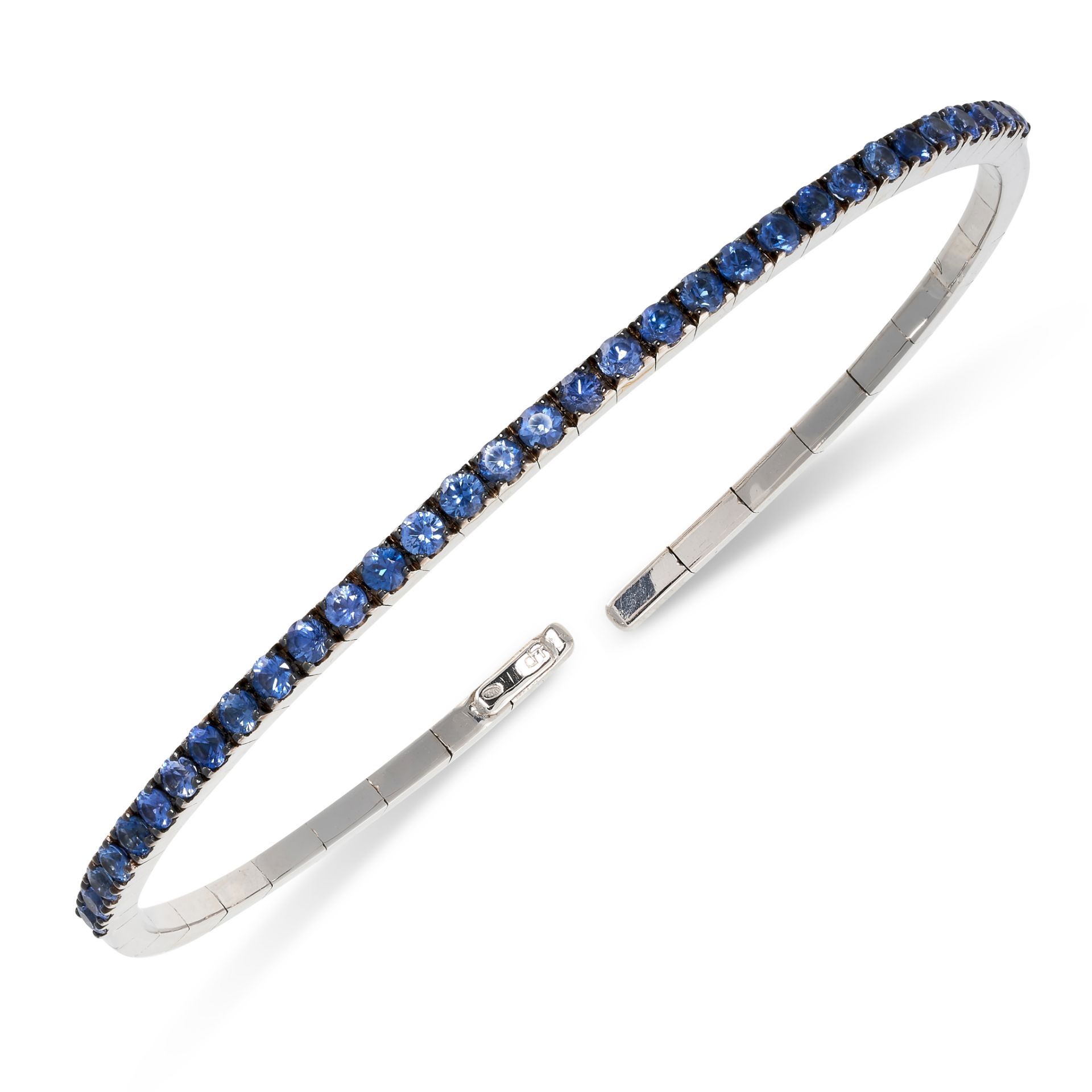 A SAPPHIRE BANGLE of flexible construction, set to the front with a line of round cut sapphires,
