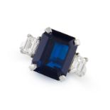 A SAPPHIRE AND DIAMOND RING set with an emerald cut sapphire weighing 8.00 carats between two step