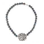 A BLACK PEARL AND SAPPHIRE NECKLACE comprising a single row of black pearls set with a clasp in