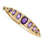 AN AMETHYST AND DIAMOND BANGLE in 9ct yellow gold, the hinged body set to one half with a row of