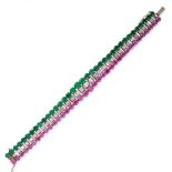 A RUBY, EMERALD AND DIAMOND BRACELET set with a row of baguette cut diamonds, between graduated rows